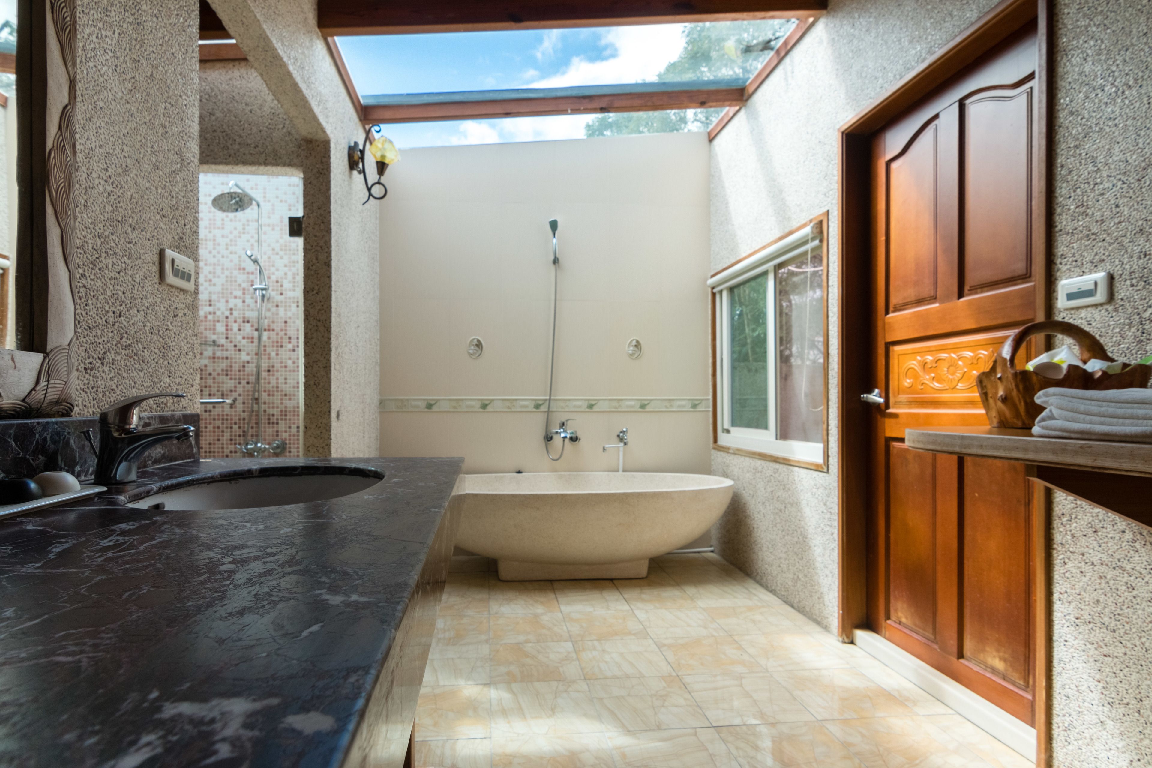 A bathroom with a freestanding bathtub, a sink, and a shower.