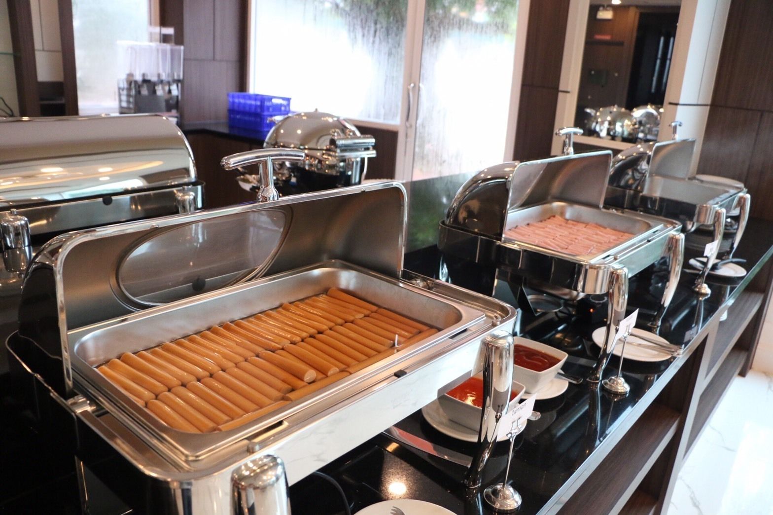 Una mesa de buffet con distintos alimentos y utensilios.