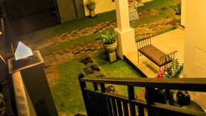 A courtyard with a paved pathway, a bench, and potted plants. - D Plus B&B Negombo (Negombo)