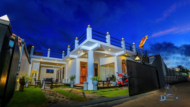 A modern two-story house with a balcony, a driveway, and a motorcycle parked outside. - D Plus B&B Negombo (Negombo)