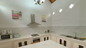 Villa romántica | Cocina privada | Cafetera y tetera, refrigerador con congelador y microondas 