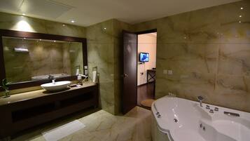 Un baño moderno con un espejo grande, un lavamanos, una bañera y un inodoro.