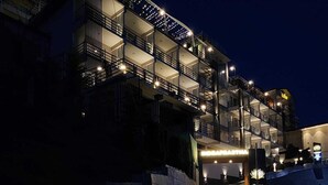 Un hotel moderno a più piani, con balconi e un ingresso ben illuminato.