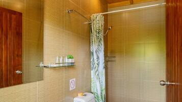 A bathroom with a wooden ceiling, a sink, a toilet, and a shower with a curtain.