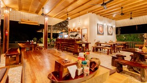 Un restaurante con mobiliario de madera y techo alto.