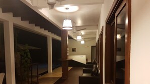A hallway with a staircase, a reception desk, and a reception area.