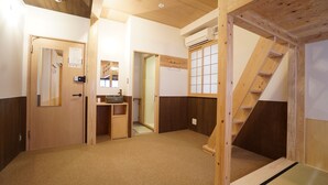 Une pièce avec un plancher en bois, un lavabo, un miroir et un escalier en bois.
