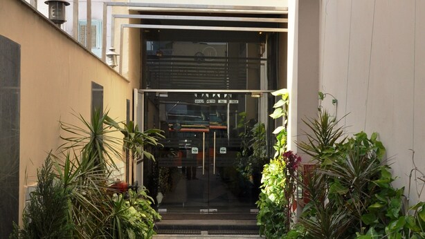 The entrance to Han's Court Inns & Hotel with a sign for reservations and enquiry contact. - Hari's Court, Lajpat Nagar (New Delhi)
