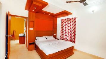 A bedroom with a wooden bed, a ceiling fan, and a red patterned curtain.
