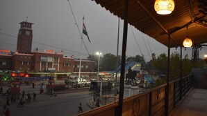 A train station with a clock tower, a flag, and a statue. - Shanti Bhawan Heritage Hotel (Jodhpur)