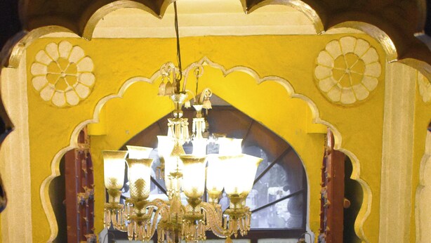An ornate entrance with a chandelier, a decorative arch, and a lattice gate. - Shanti Bhawan Heritage Hotel (Jodhpur)