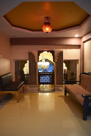 A reception area with a seating arrangement, a decorative entrance, and a chandelier.