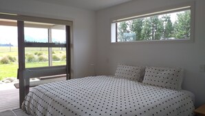 Un dormitorio con cama, ventana y vistas al exterior.