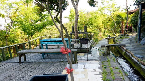 Um deck de madeira com mesas de piquenique e área de churrasco.