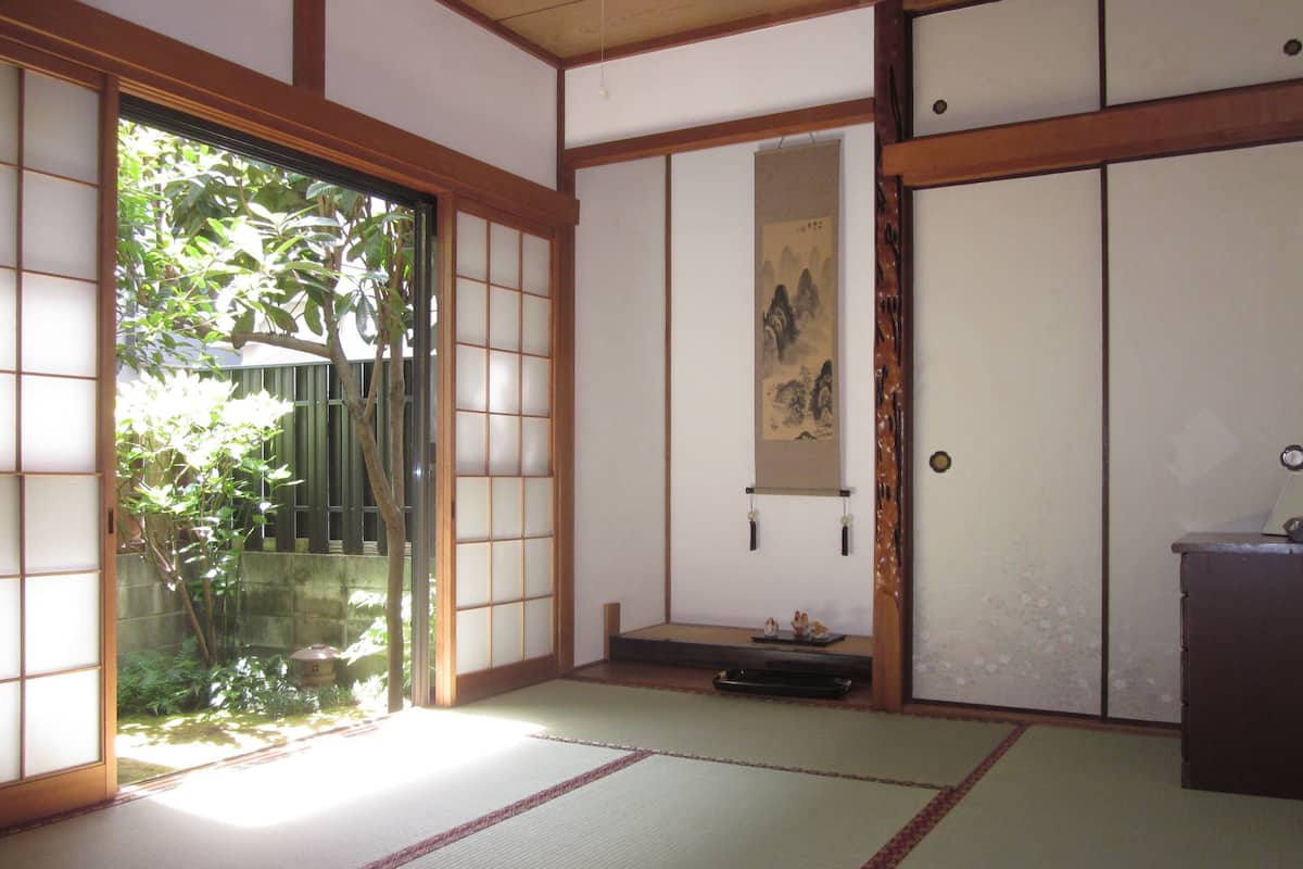 Um quarto japonês tradicional com tatames, portas deslizantes e um painel shoji.