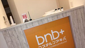 A reception desk with a sign reading "bnb+ designed hostel produced". - bnb+ Akihabara - Hostel, Caters to Women (Tokyo)