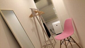 A room with a large mirror, a pink chair, and a white wardrobe. - bnb+ Akihabara - Hostel, Caters to Women (Tokyo)