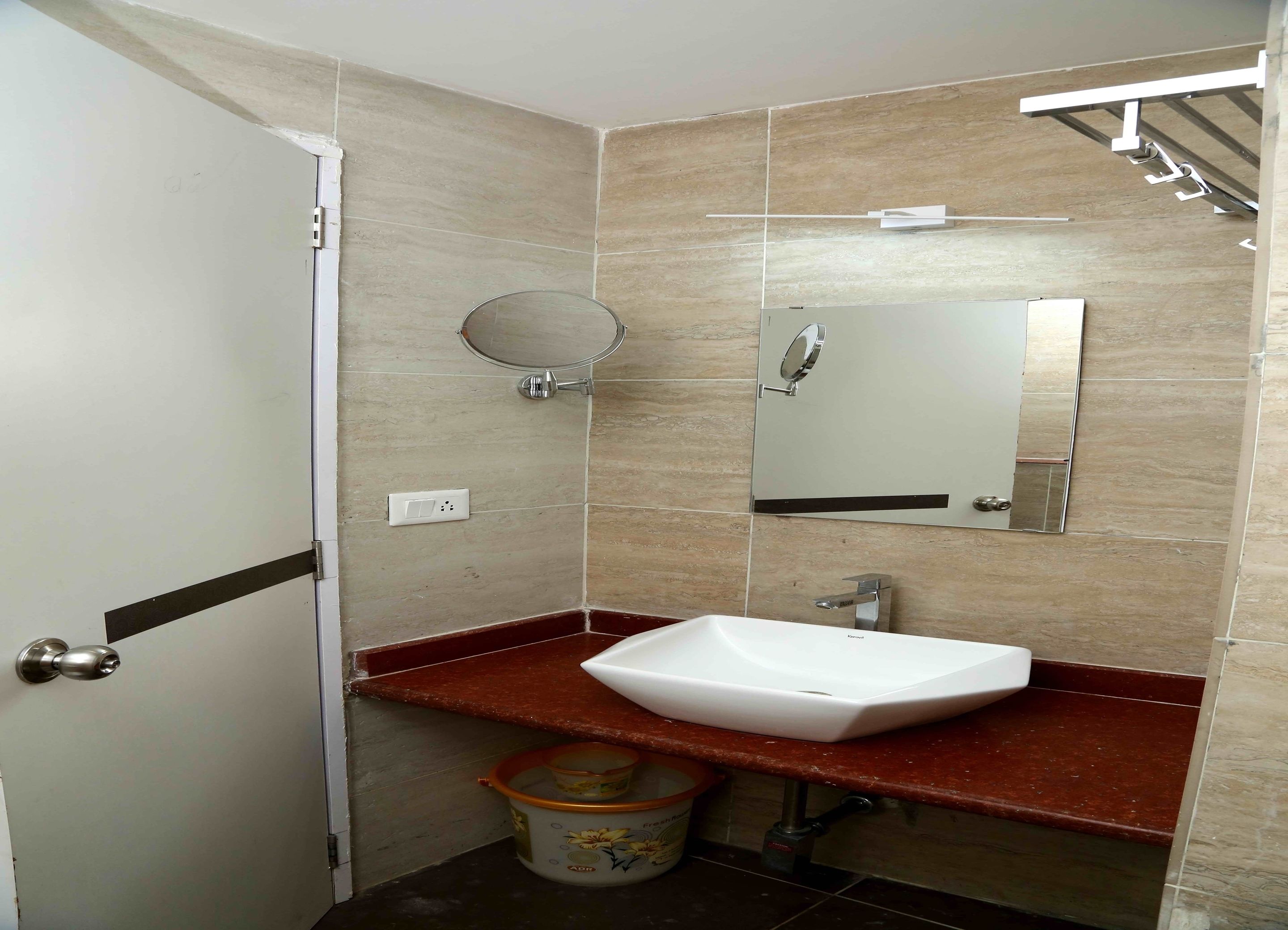 A bathroom with a white sink, a mirror, and a shower.