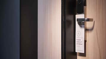 A hotel room door with a sign requesting guests to make up their rooms.
