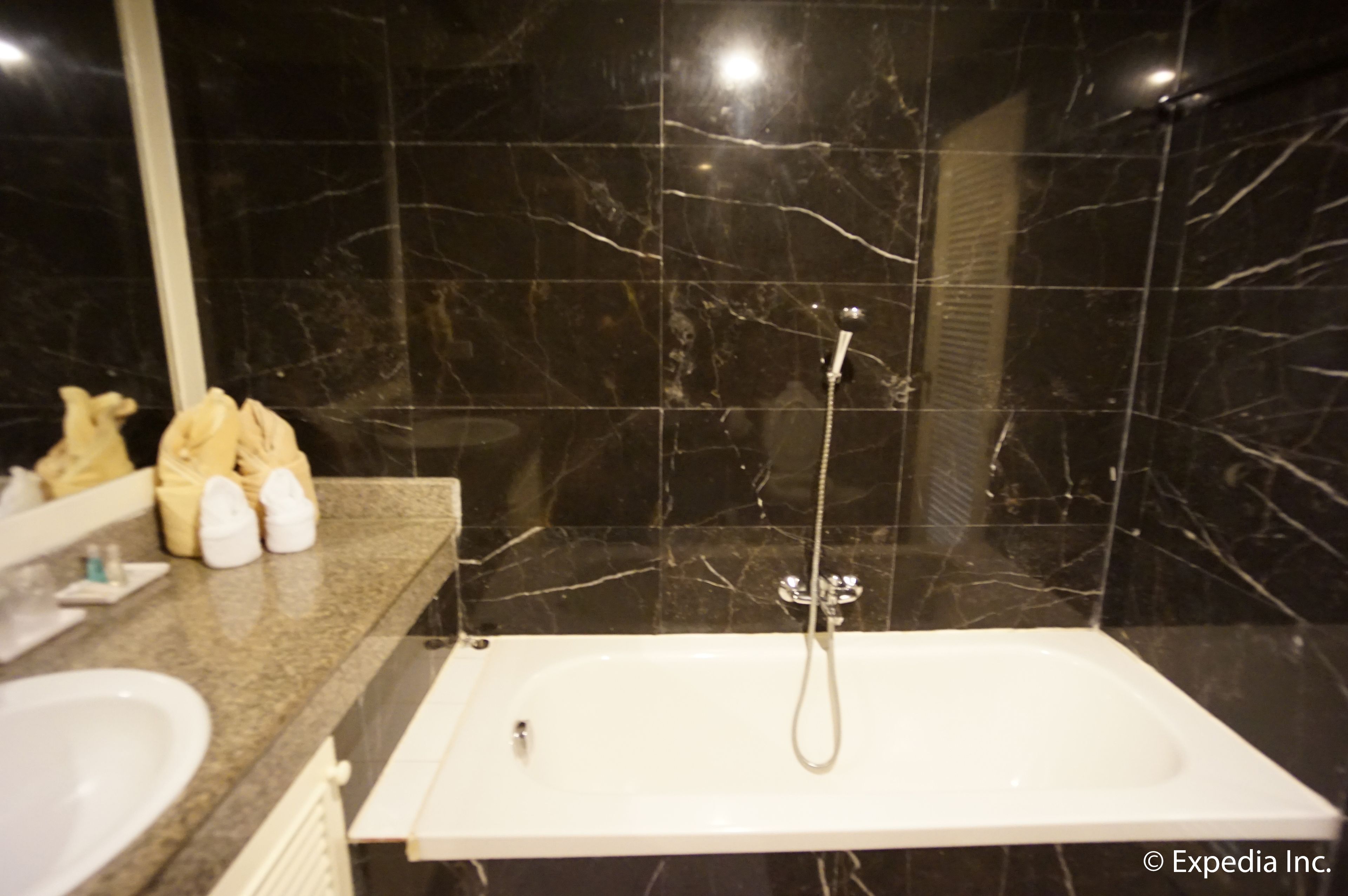 Un baño con bañera, lavamanos y espejo.