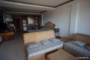 A hotel room with a large bed, a sofa, a small table, and a desk with a lamp. - Bougainvillea Terrace House (Karon)