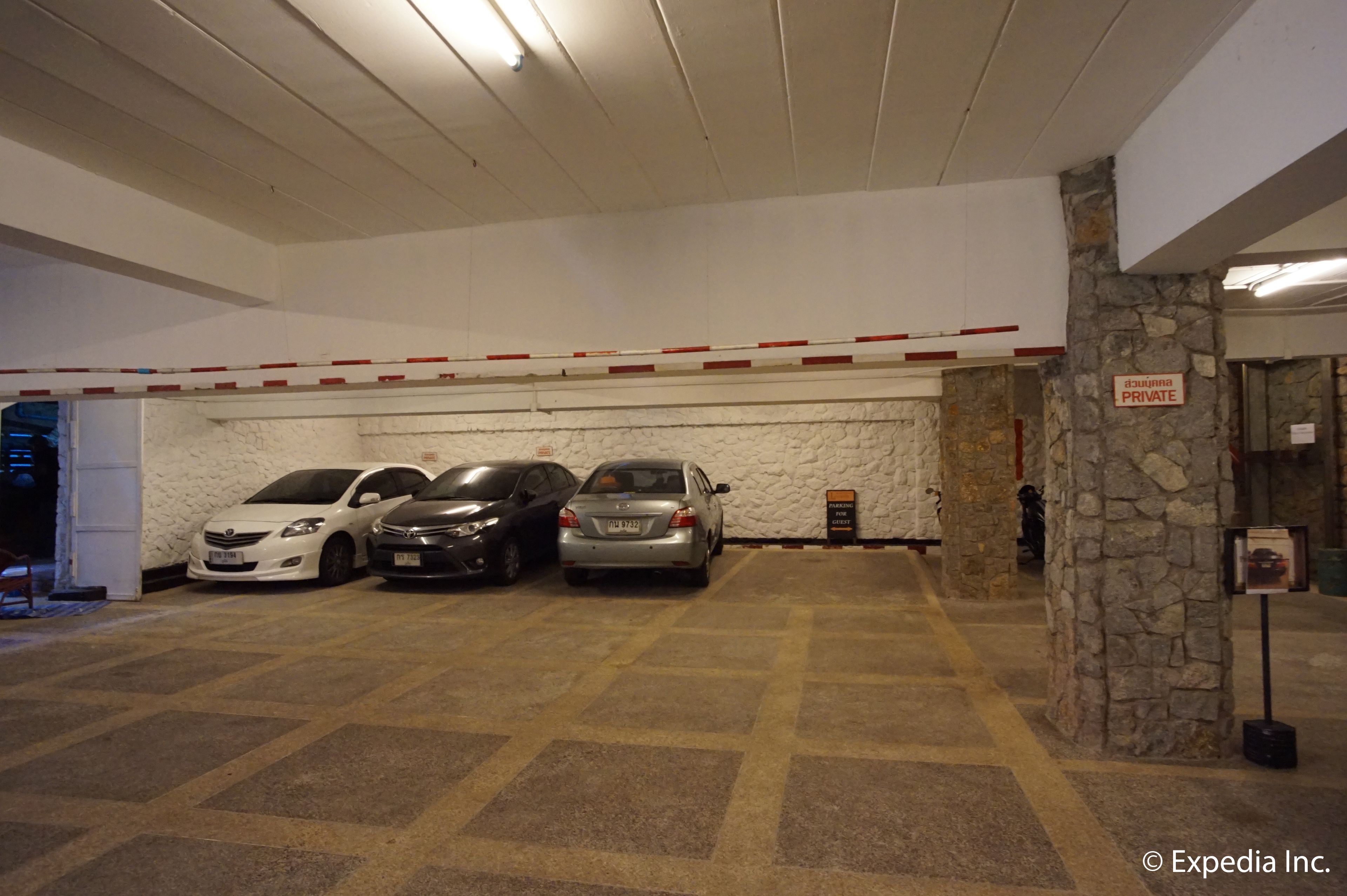 A parking garage with three cars parked in a row.