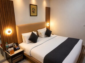 Une chambre d’hôtel avec un lit, une table de chevet et un tableau accroché au mur.