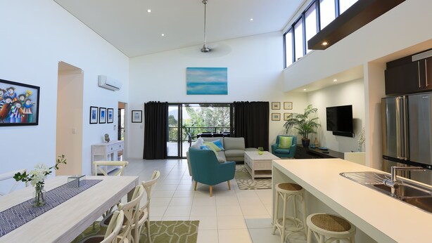 A modern living space with a dining area, kitchen, and seating area. - Hilltop Views (Cannonvale)