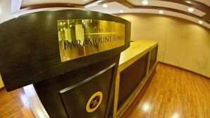 Un comptoir d’accueil d’hôtel avec une enseigne indiquant « Hôtel Paramount Tower ».