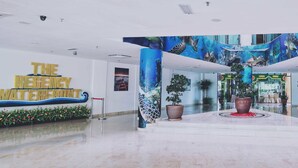 A lobby with a central atrium, a large mural depicting underwater scenes, and a sign reading "The Regal Waterfront." - The Regency Waterfront Hotel (Kuala Terengganu)