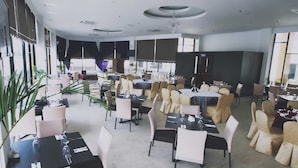A spacious restaurant with multiple dining areas, each with tables and chairs. - The Regency Waterfront Hotel (Kuala Terengganu)