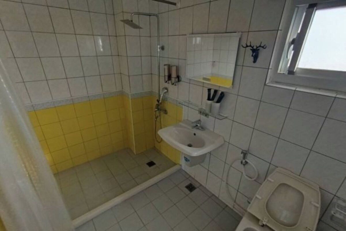 A bathroom with a shower, sink, and toilet.