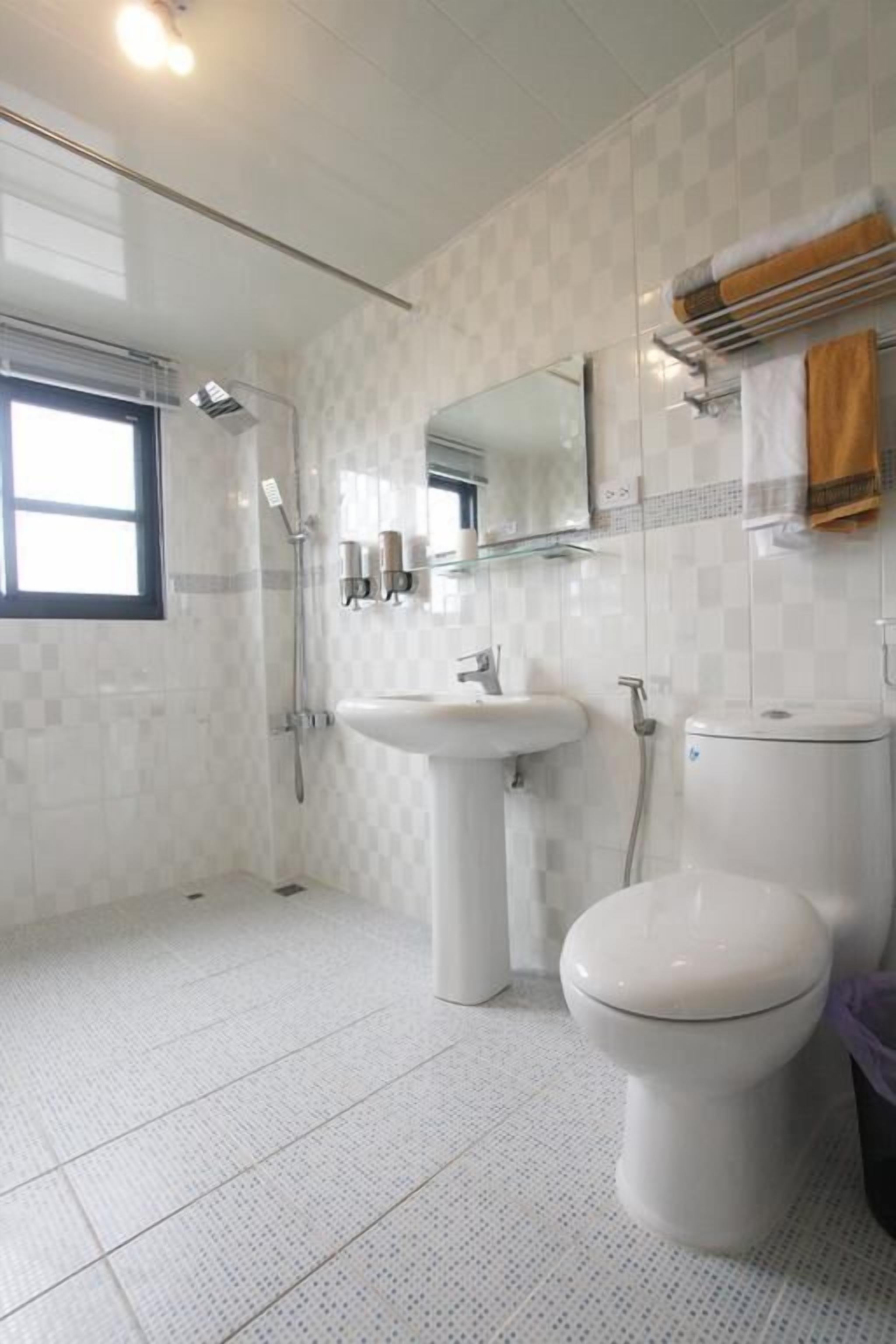 A bathroom with a toilet, sink, and shower.