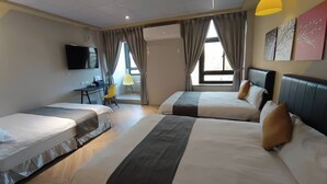 A hotel room with two beds, a desk, a chair, and a TV. - Light Shadow (Budai)