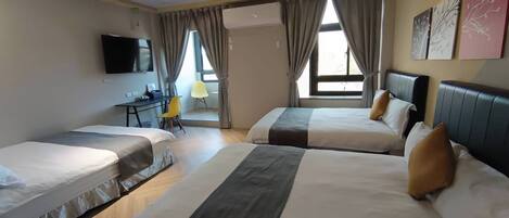 Ein Hotelzimmer mit zwei Betten, einem Schreibtisch, einem Stuhl und einem Fernseher.
