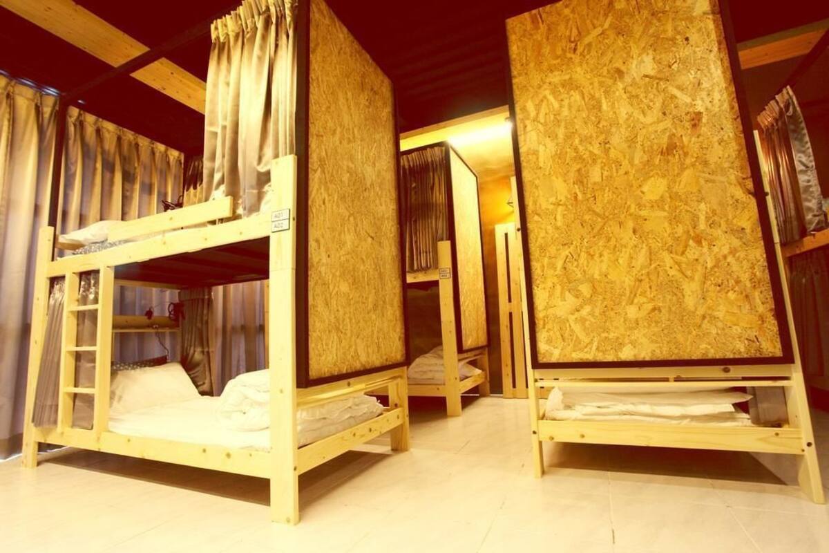 Ein Zimmer mit Etagenbetten, Holzwänden und Vorhängen.