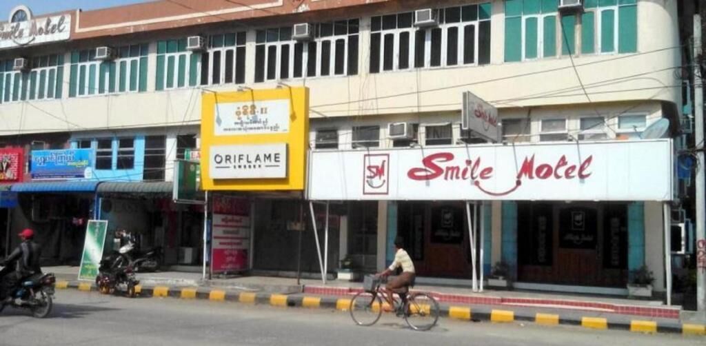 Vista de calle con un edificio que dice 'Smile Motel'.