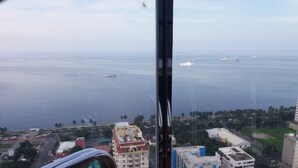 A high-rise building with a view of the sea and other buildings. - Manila Lee - Malate Bayview Mansion (Manila)