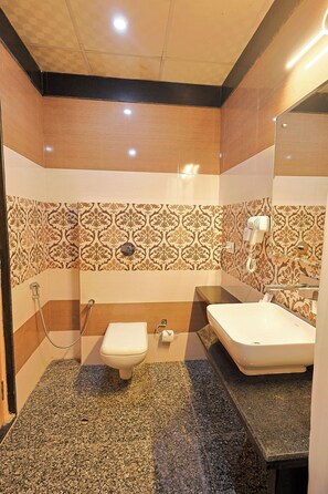 A bathroom with a toilet, bidet, and sink. - Hotel Silk City (Varanasi)