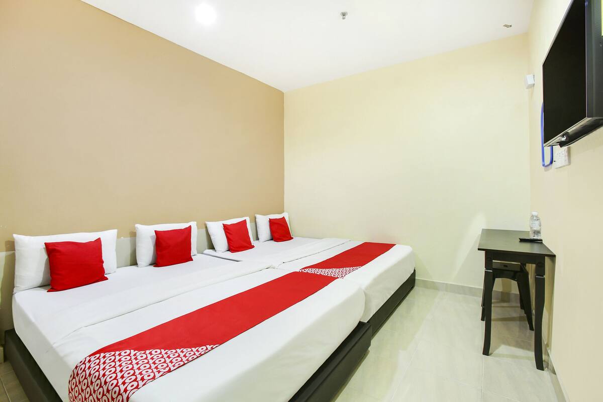 A hotel room with a bed, a desk, and a television.