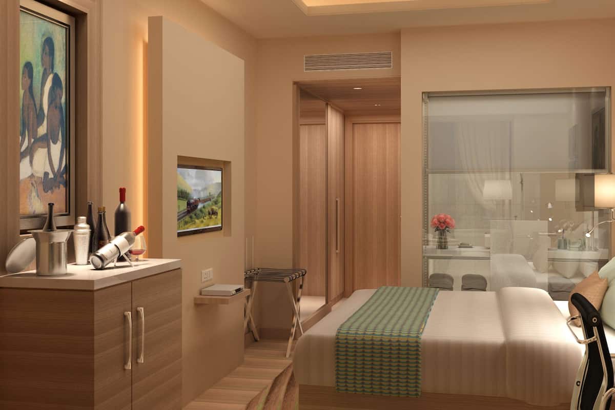 A modern hotel room with a bed, a vanity with a mirror, a dresser, and a painting on the wall.
