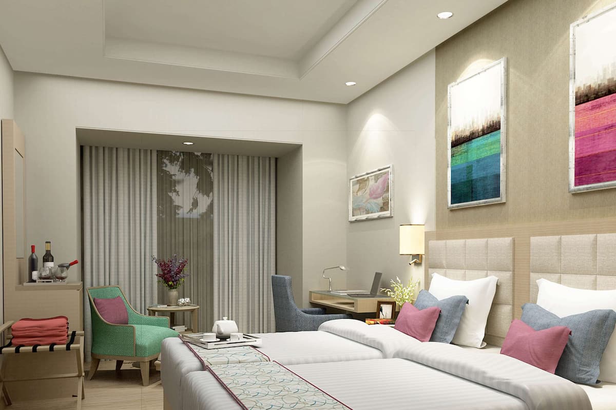 A hotel room with a large bed, a desk, a chair, and a window with curtains.