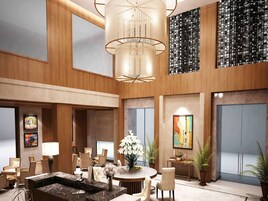 A spacious lobby with a central seating area, a large chandelier, and artwork on the walls.
