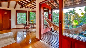 A wooden staircase leading to a balcony with a hammock. - Studios do Barão (Imbituba)