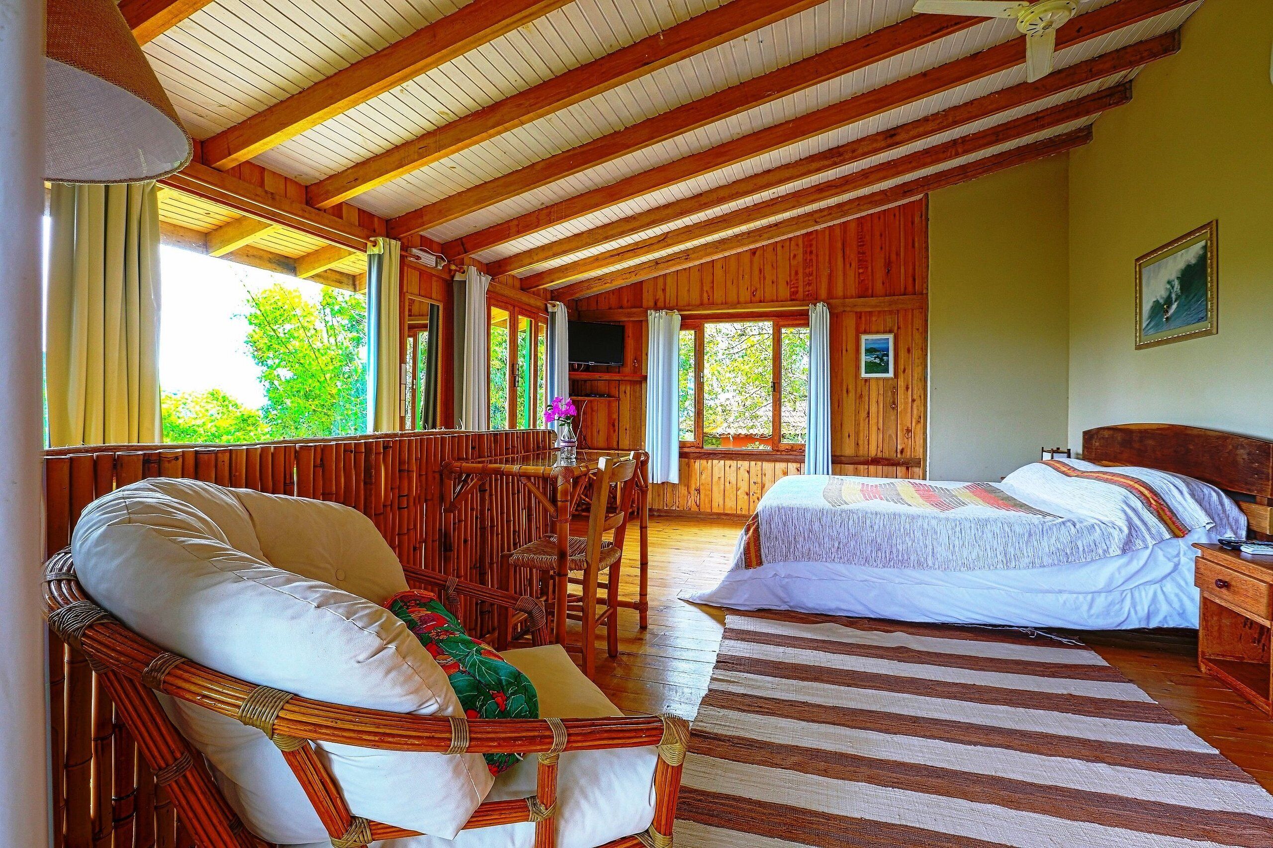 Una cabaña de madera con dos camas, una zona de comedor y ventanas amplias.