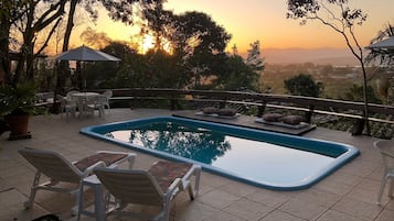 Alberca al aire libre y camastros