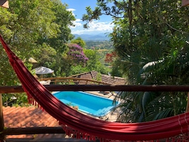 Una piscina al aire libre, sillones reclinables de piscina