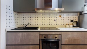 A modern kitchen with a stainless steel range hood, a sink, and a built-in oven. - Una Finestra sulle Cappelle Medicee by Mmega (Florence)