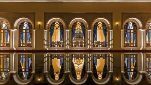 Un vestíbulo de hotel con ventanales arqueados y suelo reflectante.