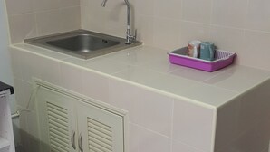 A small kitchen with a sink, cabinets, and a countertop. - Popular Condo Muangthong Thani (Pak Kret)